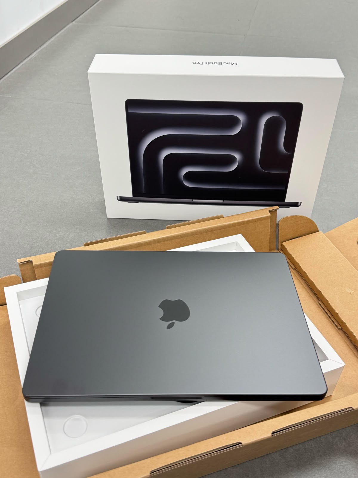 MacBook Pro in space black with its retail box
